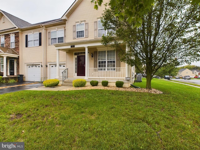 view of front of house featuring a porch, a front lawn, and a garage