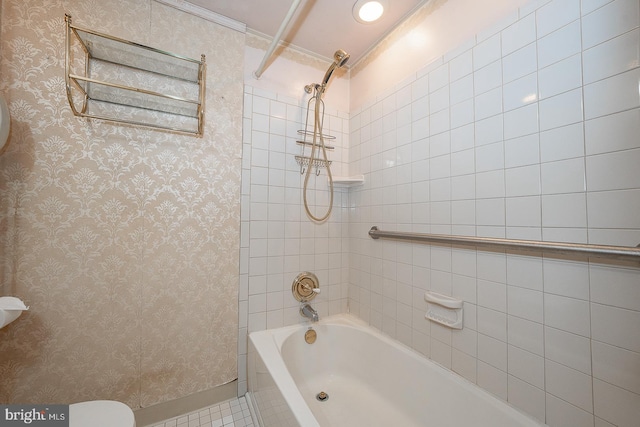 bathroom with crown molding, tiled shower / bath, and toilet