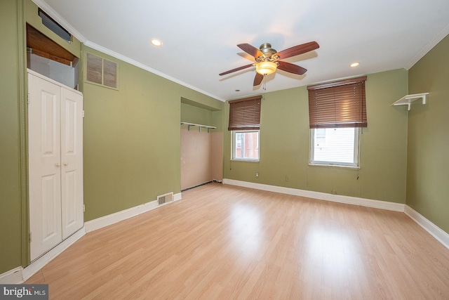 empty room with crown molding, light hardwood / wood-style floors, and ceiling fan