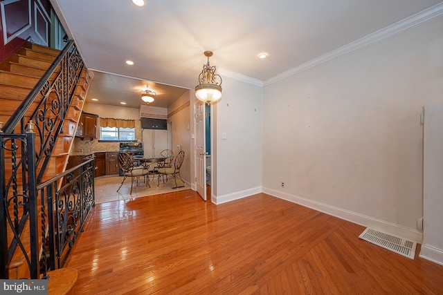 interior space featuring light wood-type flooring and crown molding