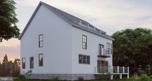 property exterior at dusk with a balcony