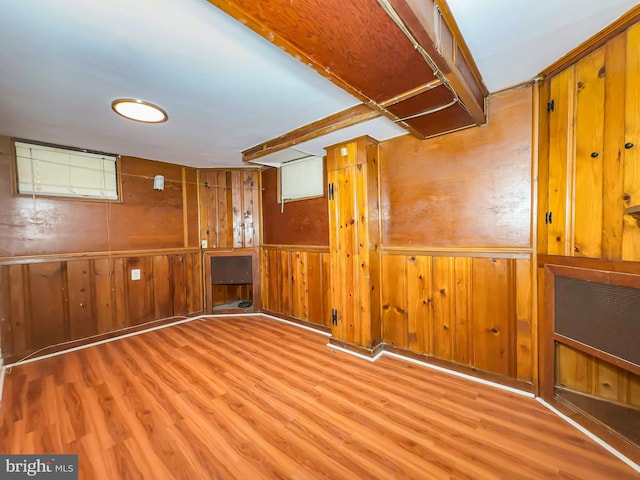 basement with wooden walls and light wood-type flooring