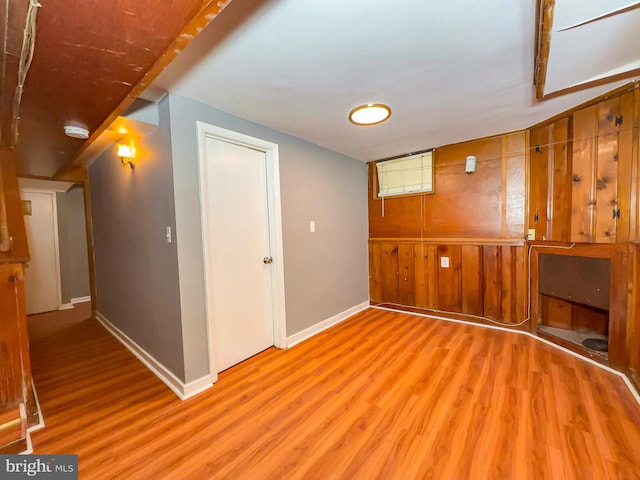 interior space with wood walls and light hardwood / wood-style flooring