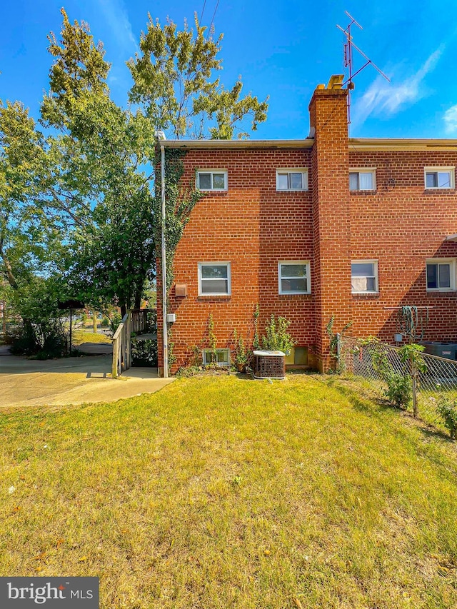 exterior space featuring a yard and central AC