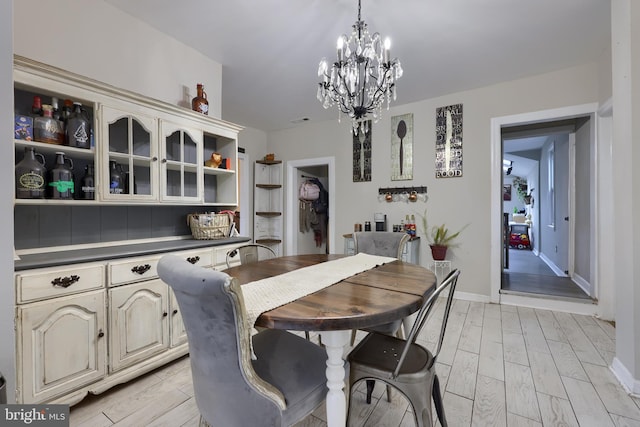 dining room with light hardwood / wood-style flooring and a chandelier