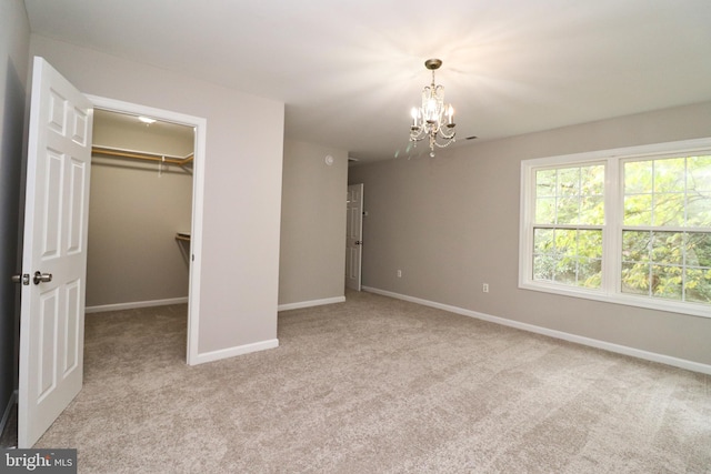 unfurnished bedroom featuring a spacious closet, a closet, and light colored carpet