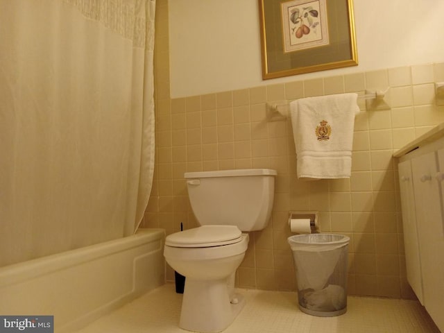 full bathroom featuring tile walls, toilet, vanity, shower / tub combo with curtain, and tile patterned floors