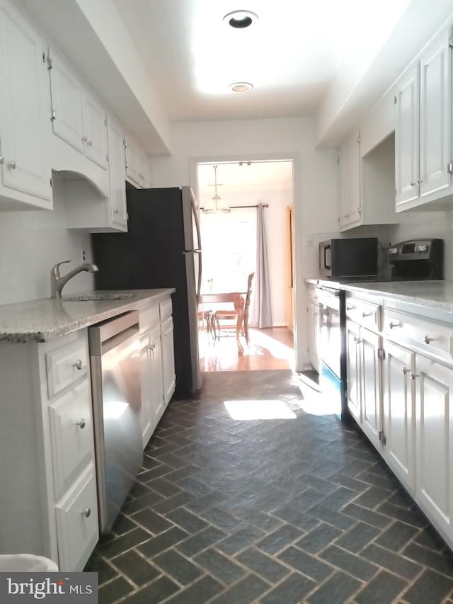 kitchen with white cabinetry, sink, and stainless steel dishwasher