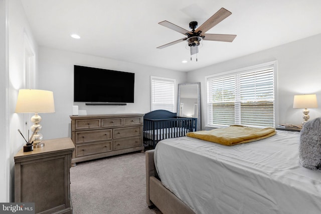 bedroom featuring light carpet and ceiling fan