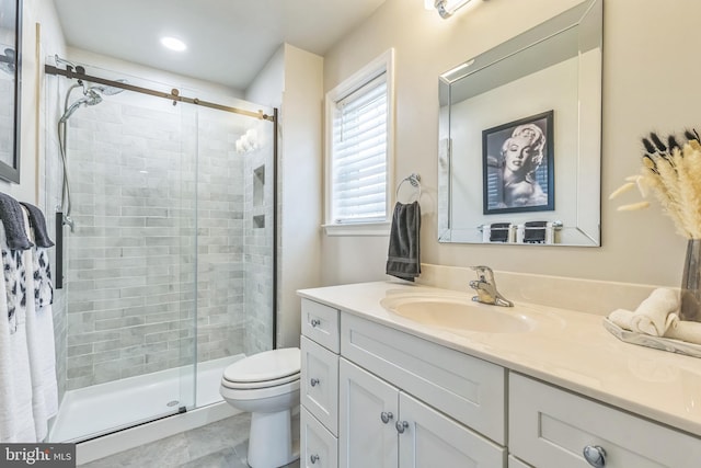 bathroom with tile patterned flooring, vanity, toilet, and a shower with shower door