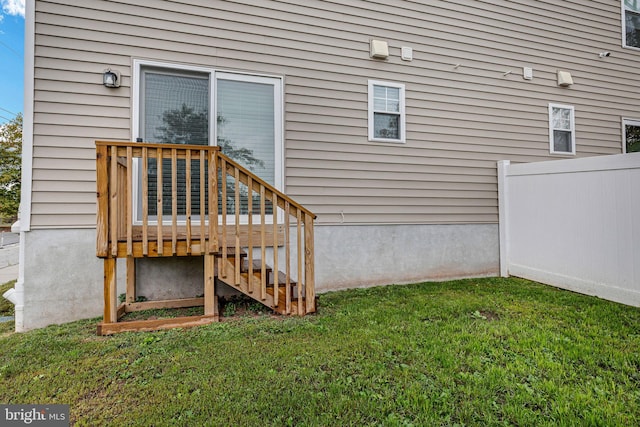 exterior space with fence and a lawn