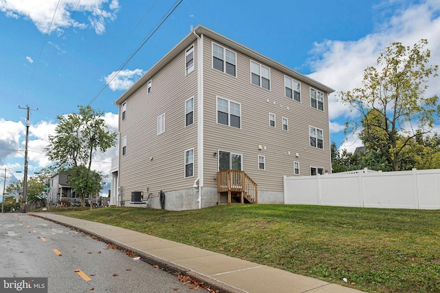 exterior space with a yard, central AC unit, and fence