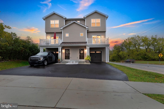 view of front of house with driveway, a balcony, and an attached garage