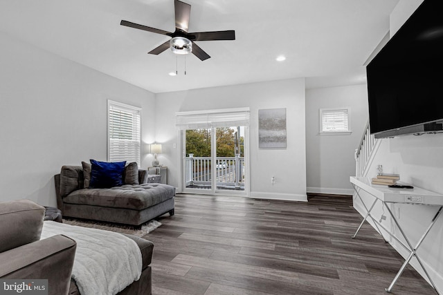 living room with ceiling fan and dark wood-type flooring