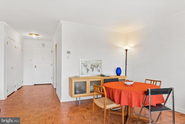 dining room featuring ornamental molding and light parquet flooring