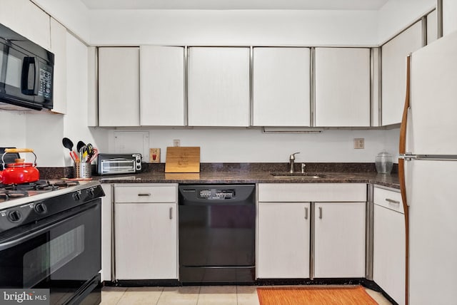 kitchen with white cabinetry, sink, dark stone countertops, light tile patterned floors, and black appliances