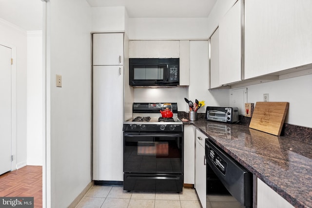 kitchen with ornamental molding, black appliances, dark stone countertops, light parquet flooring, and white cabinetry