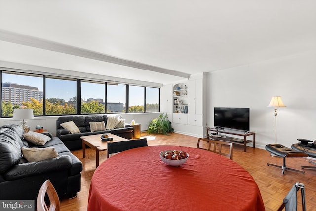 living room featuring light parquet flooring, crown molding, and a healthy amount of sunlight