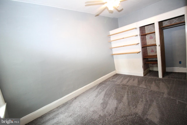 unfurnished bedroom with dark carpet and ceiling fan