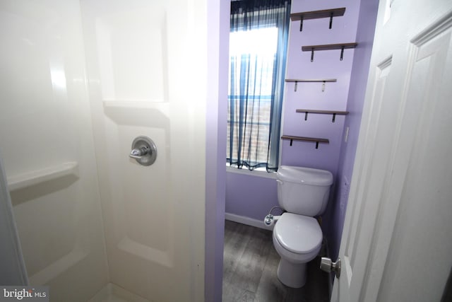 bathroom featuring a shower, toilet, and hardwood / wood-style flooring