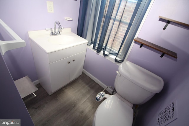 bathroom with vanity, toilet, and hardwood / wood-style flooring