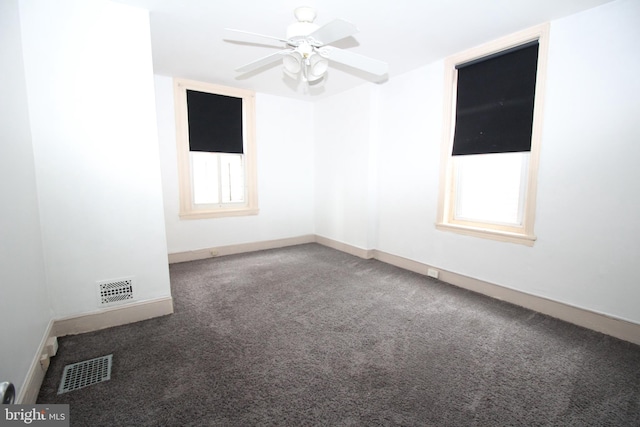 carpeted spare room with ceiling fan and plenty of natural light