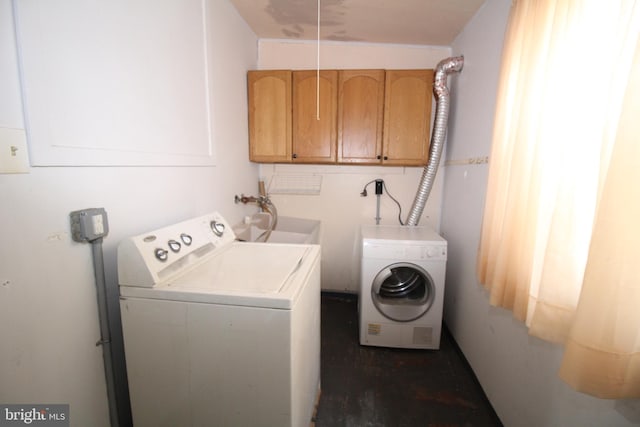 laundry area featuring sink, washing machine and clothes dryer, and cabinets