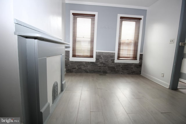 unfurnished living room with crown molding and wood-type flooring