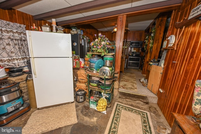 kitchen with concrete floors, wood walls, and stainless steel appliances