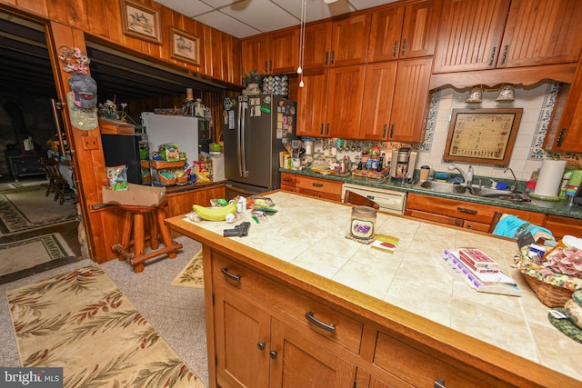 kitchen featuring light carpet, tile counters, dishwasher, and sink