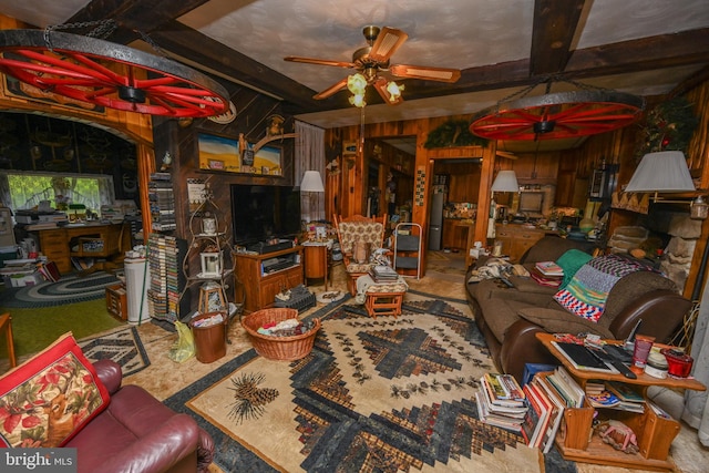 living room featuring wood walls, beam ceiling, and ceiling fan