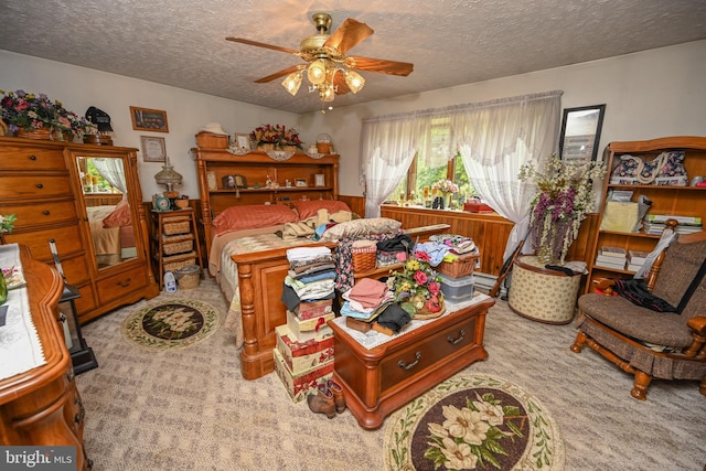 carpeted bedroom featuring a textured ceiling and ceiling fan