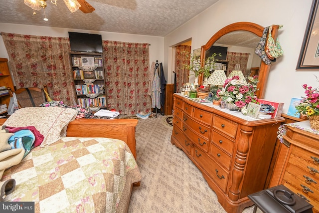 carpeted bedroom with a textured ceiling and ceiling fan