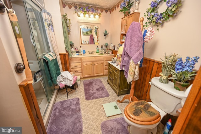 bathroom featuring vanity, a shower with shower door, and toilet