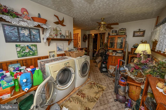 laundry room with washer and dryer, wood walls, a textured ceiling, ceiling fan, and carpet