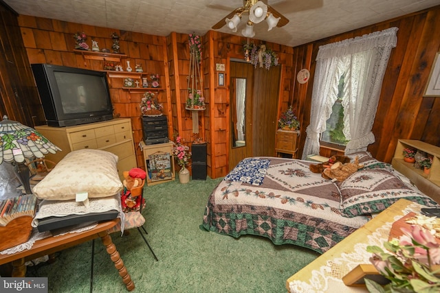 bedroom featuring wooden walls, carpet flooring, and ceiling fan