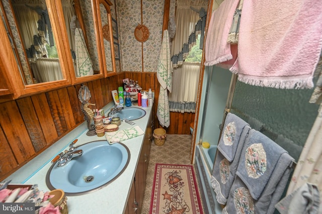 bathroom with vanity, a healthy amount of sunlight, and wooden walls