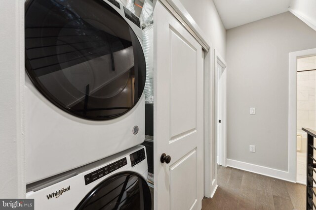 clothes washing area with dark hardwood / wood-style flooring and stacked washing maching and dryer