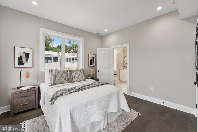 bedroom featuring ensuite bath and dark wood-type flooring