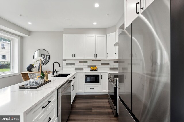 kitchen with light stone countertops, sink, stainless steel appliances, and white cabinets