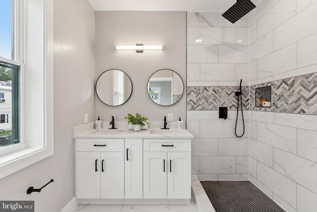 bathroom featuring a healthy amount of sunlight, a tile shower, and vanity