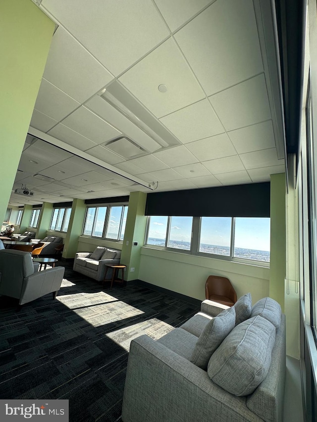 living area with a drop ceiling