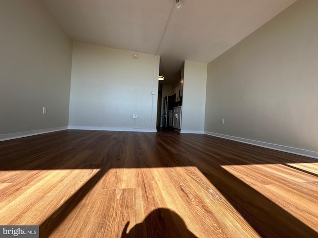 unfurnished living room featuring dark wood finished floors and baseboards