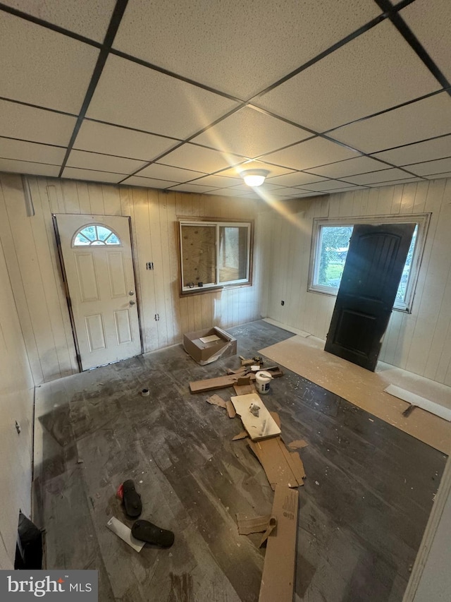 entrance foyer featuring a drop ceiling and wood walls