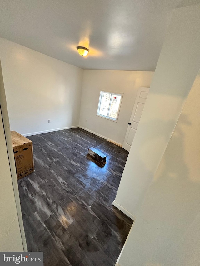 spare room with lofted ceiling and dark hardwood / wood-style floors