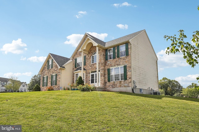 view of front of home with central air condition unit and a front yard