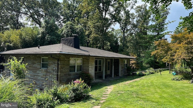 view of side of home with a yard