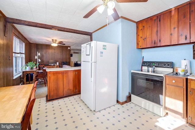 kitchen with ceiling fan, wooden walls, white appliances, and kitchen peninsula