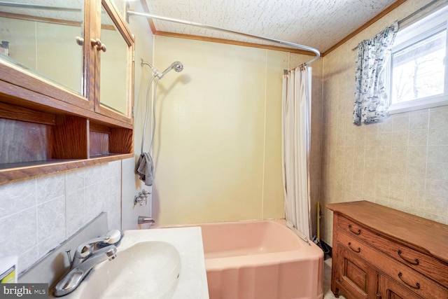 bathroom with tile walls, sink, and shower / bath combination with curtain