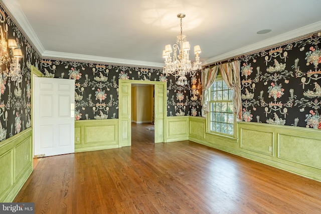 unfurnished dining area featuring crown molding, an inviting chandelier, and hardwood / wood-style flooring